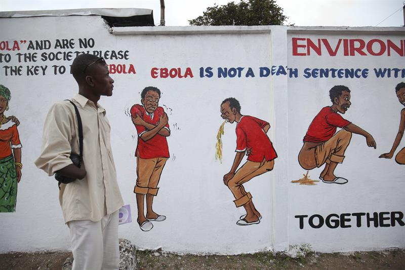 Un hombre observa un muro que lleva un mensaje de una campaña de sensibilización sobre el ébola en Monrovia, Liberia 