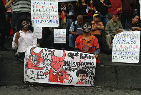 Un par de niños sostienen una manta de protesta en el Zócalo de la Ciudad de México