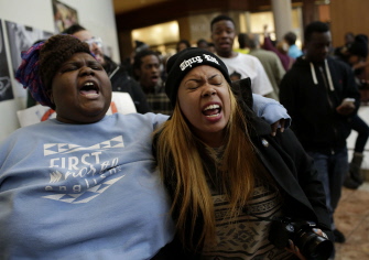 Manifestantes protestan por la muerte de Michael Brown mientras caminan hoy en una galería comercial de Saint Louis