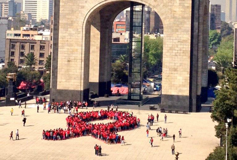 Gran moño rojo formaron decenas de personas, en el Día Internacional de lucha contra el VIH-Sida.