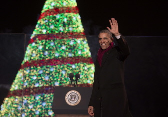 Obama saluda durante la ceremonia anual de iluminación del National Christmas Tree, en la Elipse, en Washington