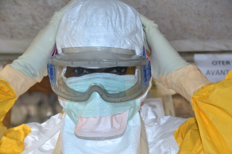 Un trabajador sanitario de Guinea, tras ponerse el traje protector en un centro de tratamiento Donka del ébola, en la capital, Conakry