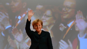 Angela Merkel saluda a los asistentes al congreso de la CDU en Colonia, tras pronunciar su discurso