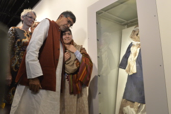 Los ganadores del Nobel de la Paz, Kailash Satyarthi (i) y Malala Yousafzai observan el vestido de la joven, cubierto de sangre, en Oslo