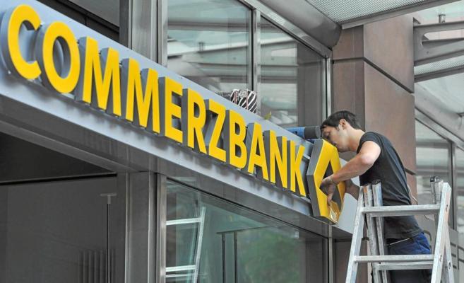 Un trabajador limpia la puerta de entrada a la sede del Commerzbank en Frankfurt, Alemania