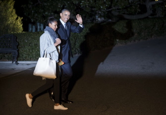 Barack Obama y su hija Sasha caminan hacia el helicóptero Marine One en la Casa Blanca para partir de vacaciones navideñas a Hawai