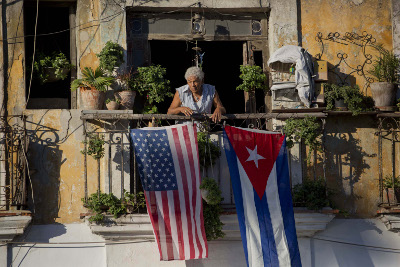 Una bandera cubana y otra estadunidense ondean en un balcón.