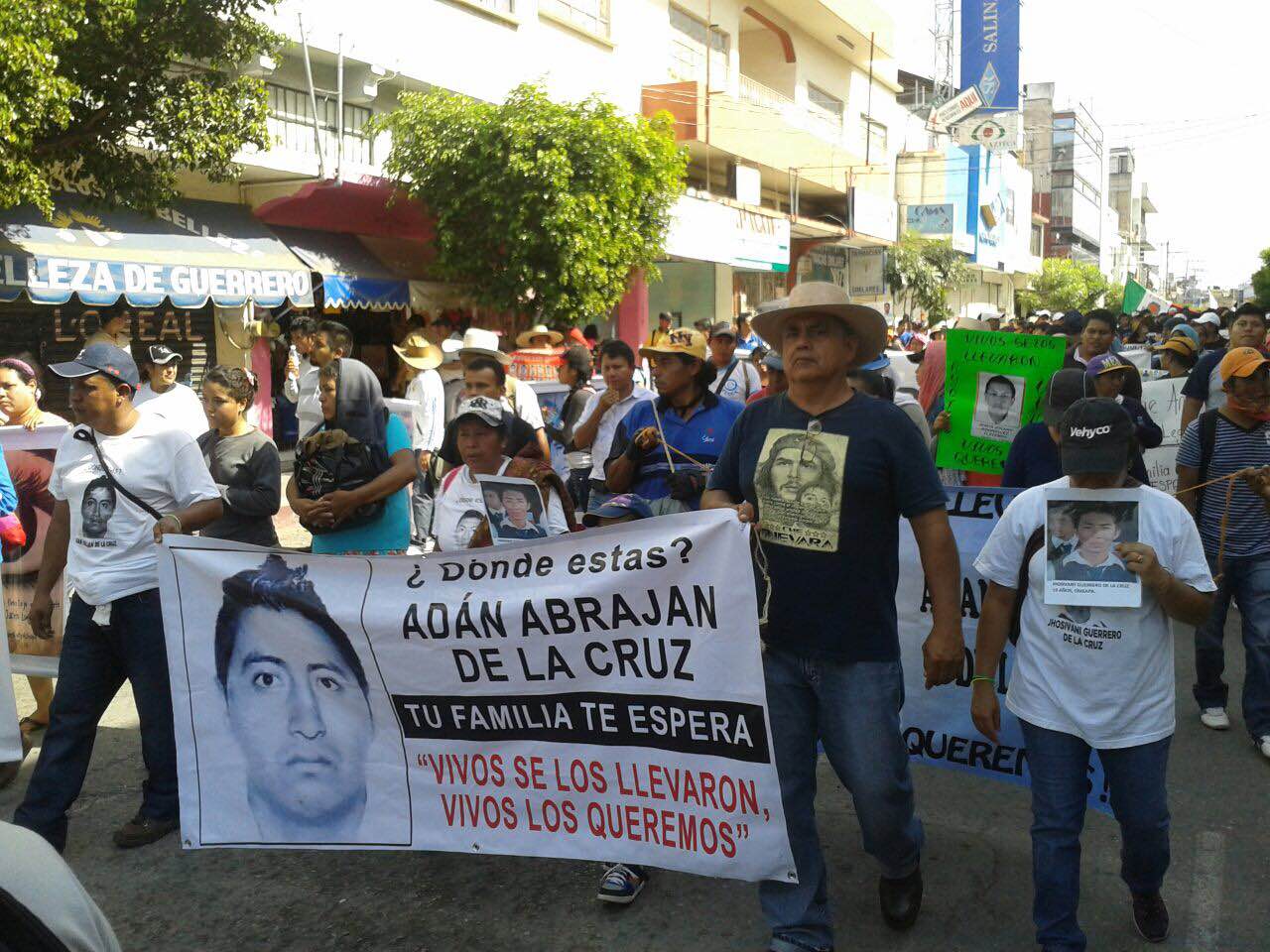 Los manifestantes llevan lonas con las imágenes de los jóvenes desaparecidos 
