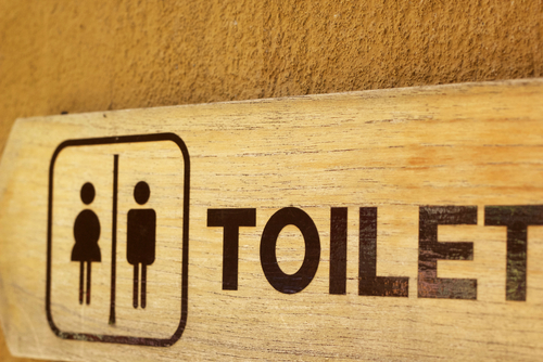Un letrero de baños públicos para hombres y mujeres.