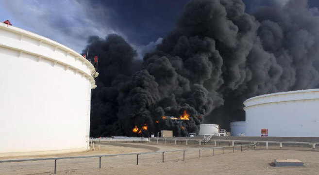 El fuego asciende desde uno de los depósitos incendiados en el puerto libio de Sidra durante los combates entre milicias