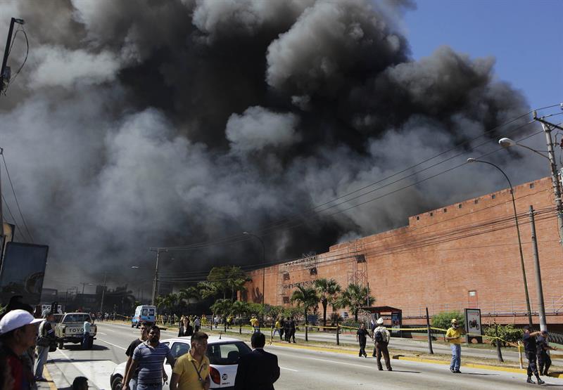 Miembros del cuerpo de socorro y bomberos intentan controlar el incendio en el centro comercial Las Cascadas, en el suroeste de San Salvador 