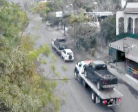 Dos grúas trasladan autos que fueron decomisados el martes. 