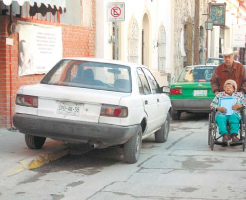 Un auto en el Barrio Antiguo invade el paso para una silla de ruedas. 