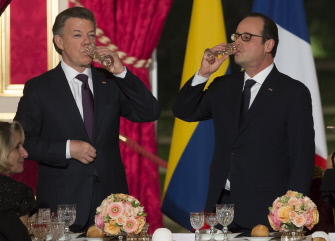 El presidente de Colombia, Juan Manuel Santos (i) y el de Francia, Francois Hollande, beben durante el banquete de hoy en el Elíseo, en París