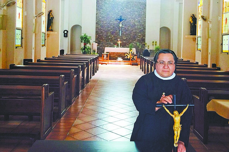 La hermana Rosario, encargada de hacer el rompope, muestra el crucifijo.