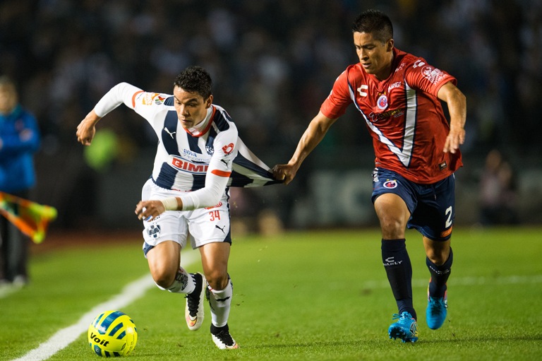 Adrián Cortés disputa el balón con Pablo Barrera de Rayados