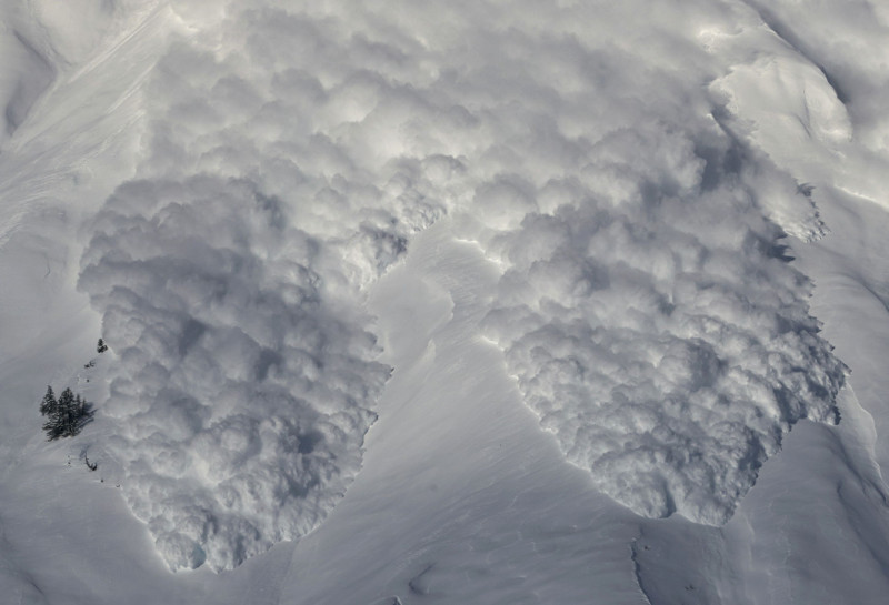 Toneldas de nieve descienden por una montaña durante avalancha provocada artificialmente en Anzere, cerca de Sion.