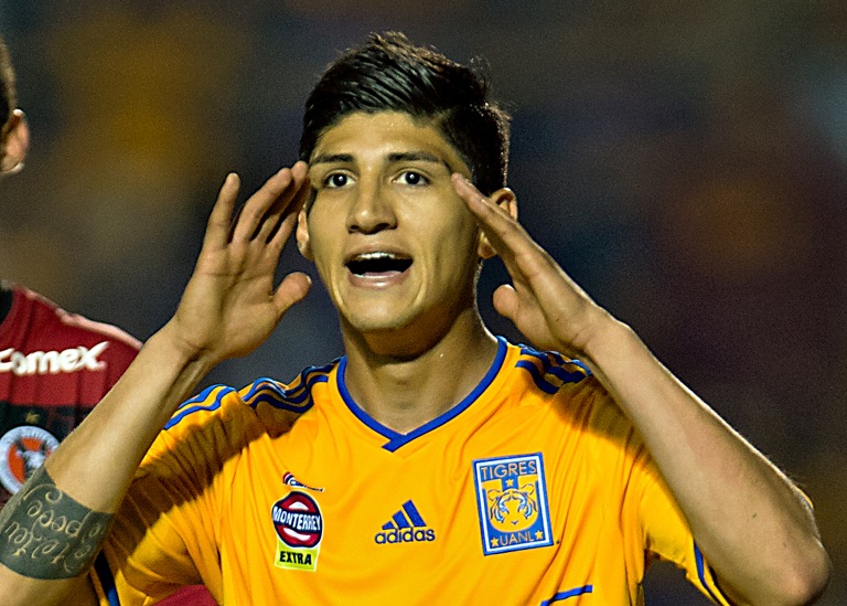 Alan Pulido disputando un partido con el equipo felino.