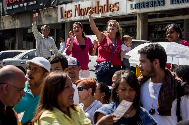 La diputada Dinorah Figuera (c-abajo) acompaña a los ciudadanos que hacen fila ante un supermercado Bicentenario en Caracas