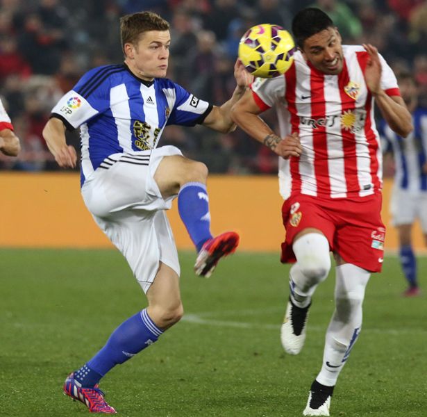 El defensa argentino del Almería Mauro Dos Santos (d) lucha el balón con el islandés Alfred Finnbogason, de la Real 