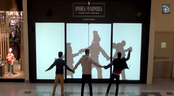 Las sombras de Donald, Goofy y Mickey bromean con unos jóvenes.