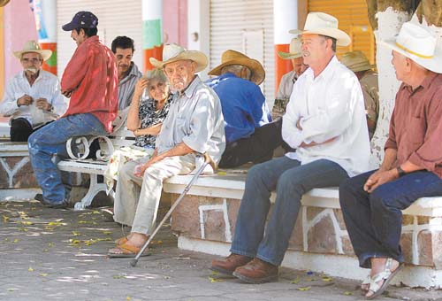 En la plaza principal de Arteaga los ancianos descansan o juegan naipes para no morir de aburrimiento.