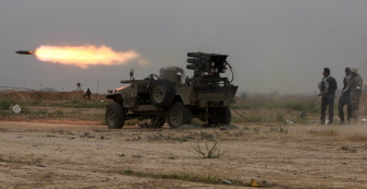 Combatientes chiítas iraquíes lanzan proyectiles contra posiciones del Estado Islámico en el centro de Tikrit