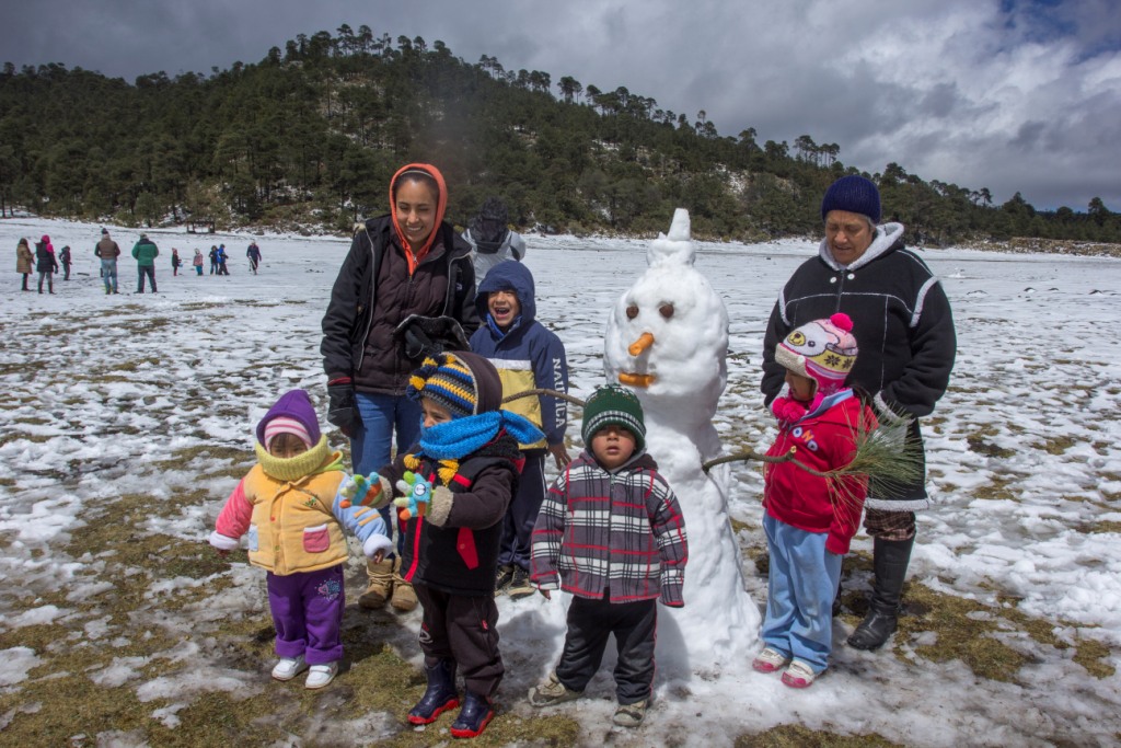 Niños y adultos aprovecharon la nevada en el Ajusco para hacer muñecos de nieve.