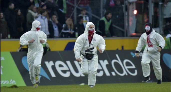 Una treintena de ultras del Colonia, ataviados con trajes químicos blancos, saltaron al césped del campo del Borussia Mönchengladbach cuando estos cel
