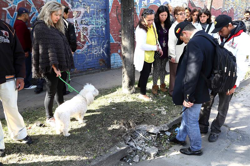 Varios vecinos observan el lugar donde tuvo lugar la explosión esta mañana, en Bogotá