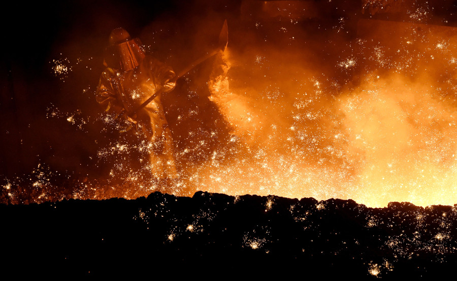 Un hombre pone arena en un horno de una empresa acerera en Salzgitter.