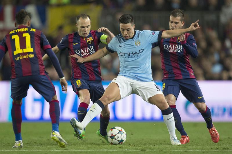 Andrés Iniesta y Samir Nasri en la disputa del balón