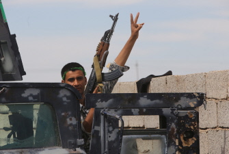 Un miembro de las fuerzas gubernamentales iraquíes hace el signo de la victoria en las afueras de Tikrit 