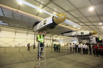Un técnico examina al Solar Impulse 2 en un hangar tras su aterrizaje en el aeropuerto de Chongqing