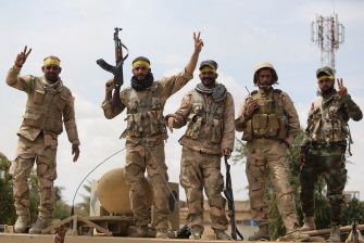Milicianos chiitas de las unidades de movilización popular hacen el signo de la victoria en Tikrit, tras haber derrotado a los yihadistas del EI