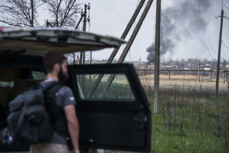 Un observador de la OCDE mira una columna de humo causada por un mortero en el barrio de Jabunki, cerca del aeropuerto de Donetsk 