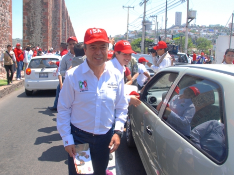 César Camacho repartió calcomanías entre el tránsito vehicular de Querétaro.