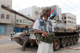 Miembros del movimiento separatista del sur de Yemen, leales al presidente Hadi, junto a un tanque en los suburbios del norte de Adén