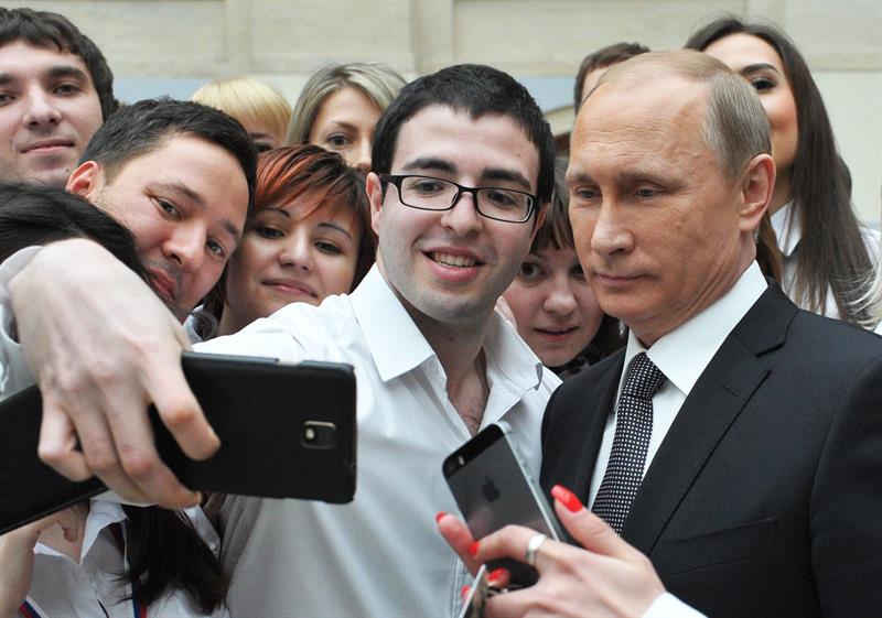 Putin (d) se hace una fotografía con los empleados de la televisión en la que se ha emitido su tradicional programa "Línea Directa", en Moscú