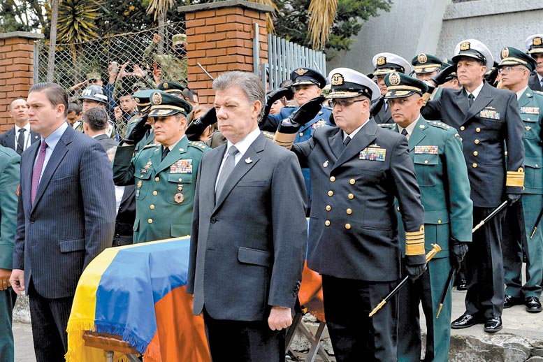 El jefe de Estado (derecha) y su ministro de Defensa, Juan Carlos Pinzón ( izq ) ayer en las honras fúnebres a uno de los 11 soldados muertos.
