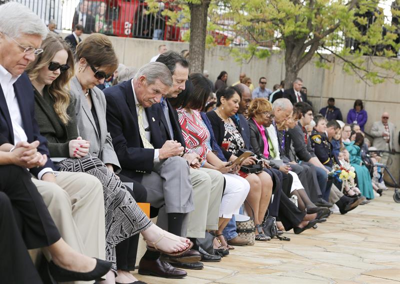 Asistentes a la ceremonia inclinan sus cabezas durante 168 segundos de homenaje a las 168 víctimas mortales del atentado en Oklahoma City 