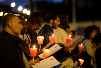 Activistas de una asociación católica rezan con velas frente al cementerio de Verano en Roma, en memoria de las víctimas del naufragio