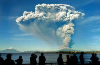 Varias personas observan desde Puerto Varas, en el sur de Chile, la columna de lava y cenizas que asciende desde el volcán Calbuco