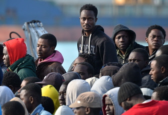 Migrantes rescatados esperan a ser desembarcados del barco Denaro, de la Guardia di Finanza italiana, en el puerto siciliano de Catania