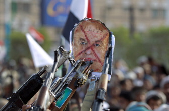 Milicianos y seguidores de los rebeldes chiitas hutíes apuntan a un retrato del presidente Abed Rabo Mansur Hadi, en una manifestación en Saná 