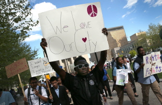 Estudiantes de la  Digital Harbor High School cantan "We Love Baltimore" ("Amamos Baltimore") al marchar ante el ayuntamiento de la ciudad