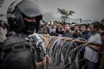 Policías antidisturbios permanecen alertas ante supervivientes del sismo que protestan al no encontrar camiones para salir de Katmandú