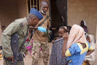 Dos militares nigerianos, junto a un grupo deniñas rescatadas en la operación contra Boko Haram en la selva de Sambisa, en el estado de Borno