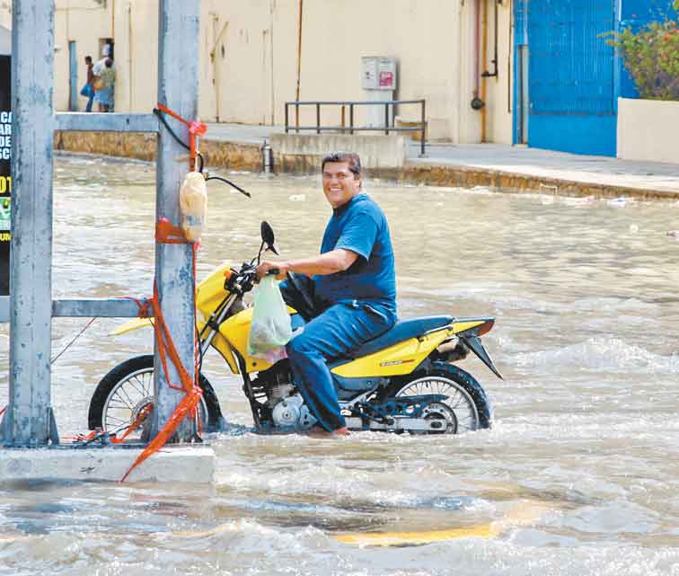 La gente trata de movilizarse por las calles inundadas.