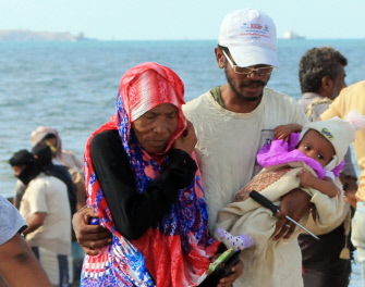 Yemeníes caminan en una playa del barrio de Tawahi, en Adén, antes de tratar de huir del país por mar